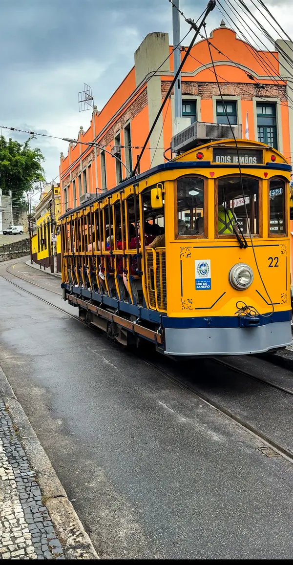 Historic yellow Santa Teresa tram on cobblestone streets in Rio de Janeiro